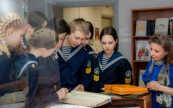 Заведующая читальным залом Е.В. Никандрова показывает кадетам документы воспитанников Морского кадетского корпуса